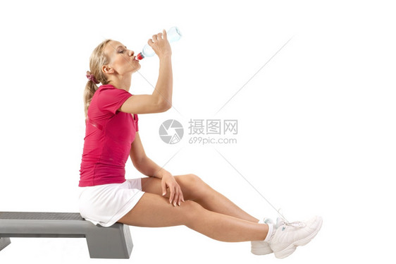 年轻美丽的女子在参加运动后饮喝水白色的机场在室内图片