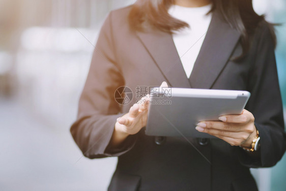 办公室一名手握数字平板电脑设备的妇女装模作样小读图片