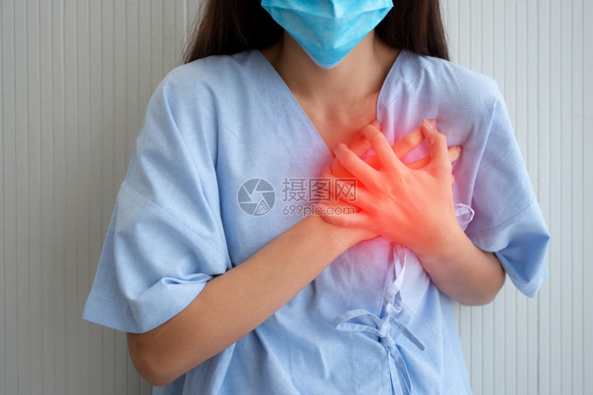 女士因心脏病发症状而戴面罩和手握胸前的女病人中风攻击图片