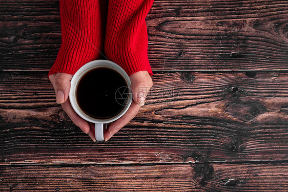 穿红色毛衣女性手持咖啡杯图片