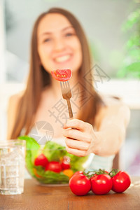 食物笑着的caucasian女人吃沙拉的照片黑发图片