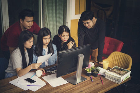 寻找严肃面对办公电脑的亚洲自由职业工团成员Asian自由职业者小组更年轻脸纸图片