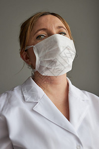 身穿制服戴着口罩的女医生图片