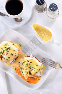 黄油蛋在一条肉汁船上的荷兰奶油酱早餐配鸡蛋本尼迪克特炸英国面包火腿偷吃鸡蛋一杯咖啡浇水图片