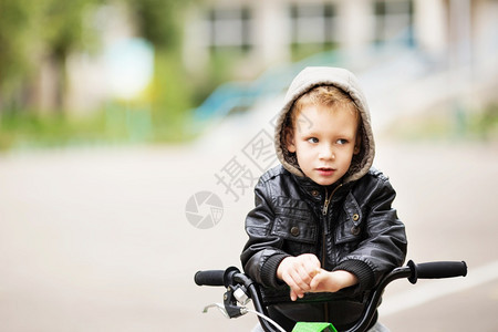 英俊的生活穿着黑色皮夹克的可爱小城市男孩肖像风格孩子这男学会骑自行车孩子驾驶自行车孩子驾驶脚踏车情感图片