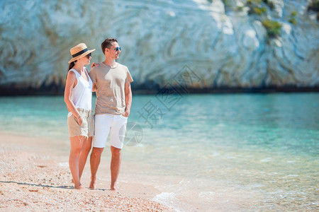 蓝色的暑假期间在海滩上的年轻家庭暑假期间在白色海滩上的年轻夫妇水图片