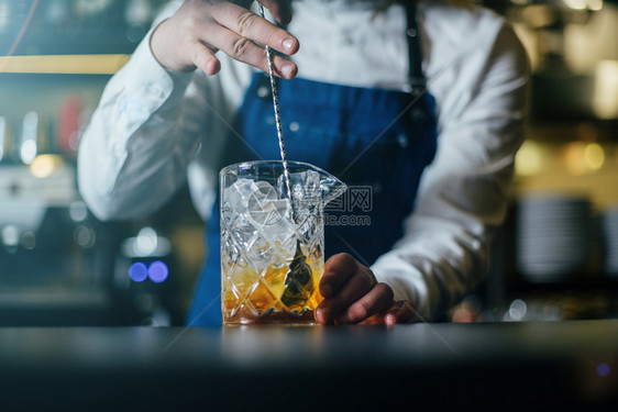 成人专业的酒保与OM做饮料和鸡尾酒柜台威士忌图片