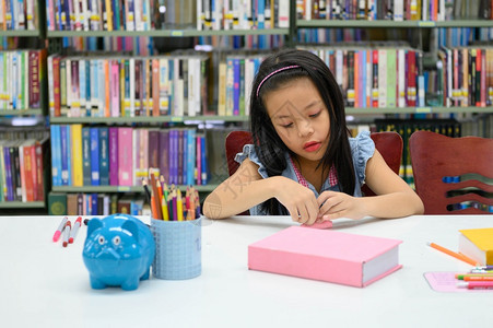 在室内书架艺术课期间图书馆折叠和编造亚洲女孩的论文教育与活动概念折纸图片