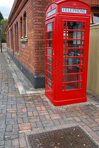 讲话玻璃电信背景上典型的红色电话亭和砖墙建筑红式电话亭和砖墙图片