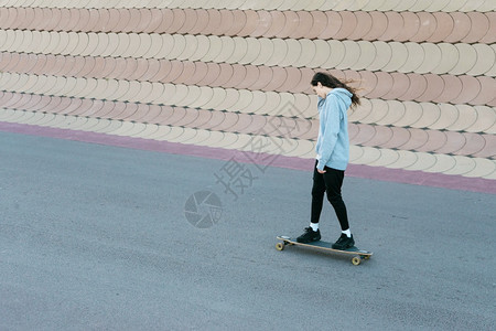 时尚假期年轻女孩在阳光明媚的一天在城市公园的长板滑冰西班牙裔图片