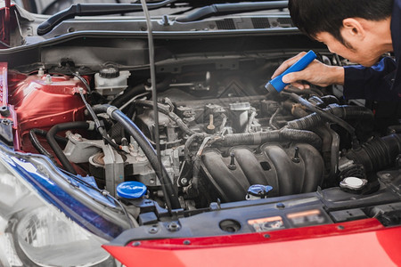 亚洲人机械检查用火炬汽车发动机检查引擎中的错误蓝色汽车用于服务维护保险与汽车发动机用于运输汽车一种工作指点图片