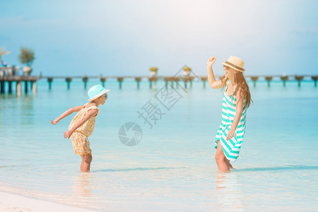 户外年轻美丽的母亲和可爱小女儿在热带海滩玩得开心在加勒比海滩享受暑假的美丽母亲和女儿在加勒比海滩过着愉快的时光乐微笑图片