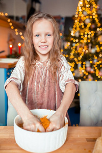 手放桌子可爱的快乐小女孩在平安夜烤圣诞姜饼干可爱的小女孩烤圣诞姜饼干图片