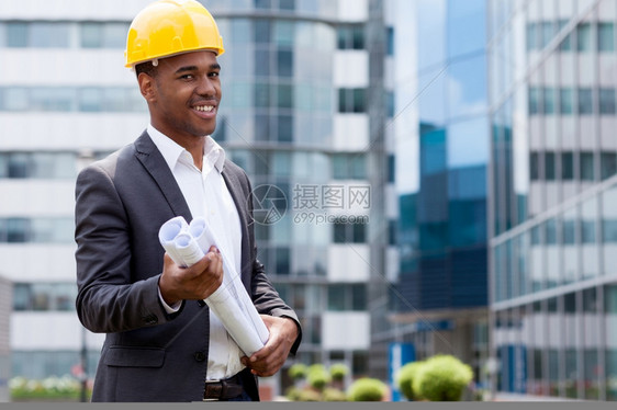 服务工人建筑持有蓝图前的非裔美国建筑工程师在房持有蓝图之前领班图片