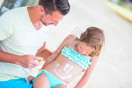 父亲在女儿身上涂防晒霜图片