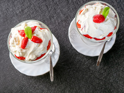 绿色寒冷的黑暗两碗草莓和生奶油顶视图深色背景中两碗草莓和生奶油图片