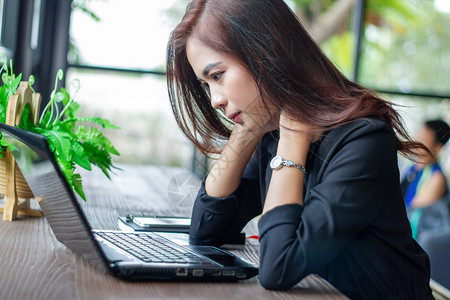 桌子白色的亚裔女商人认真对待所做工作直到头痛为止女孩背景