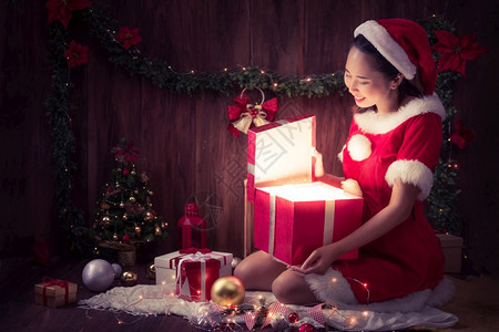 灯笼微笑圣诞快乐和新年时打开礼物盒一个穿着圣诞老人服装的漂亮女很高兴她打开了礼物箱女士图片