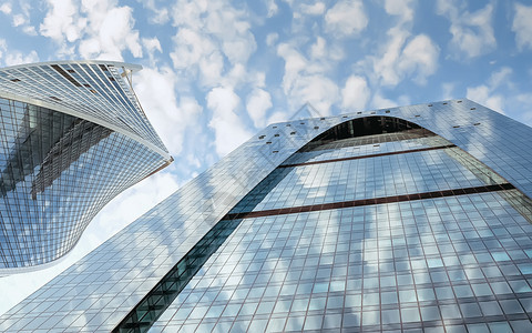 城市的分段蓝色办公室楼顶玻璃墙上反射云彩的蓝办公楼顶玻璃墙上反射着云雾城市图片