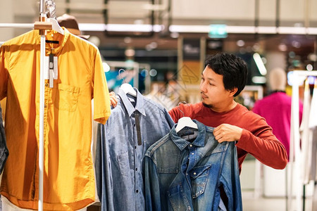 与衬衫时装风格和消费主义概念之间的差别比较在购物中心服装商店选择的有胡子聪明男比较衬衫样式和消费主义概念胡须曼谷男人图片