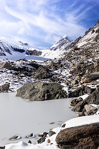 冒险远足雪和蓝天空下山顶攀爬着岩石阿尔泰山峡谷的冬季全景美丽图片