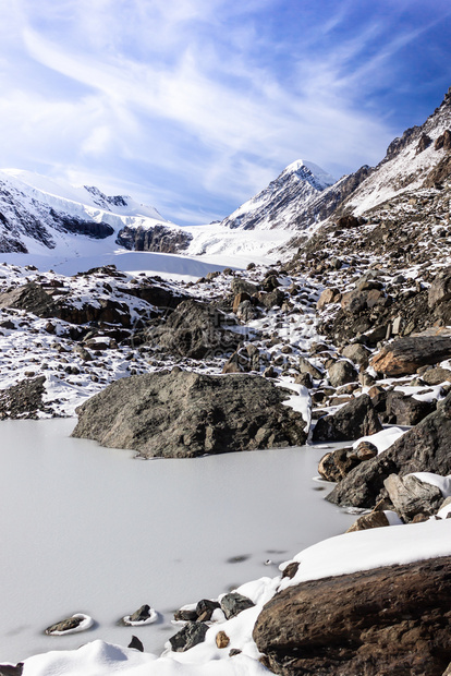 冒险远足雪和蓝天空下山顶攀爬着岩石阿尔泰山峡谷的冬季全景美丽图片