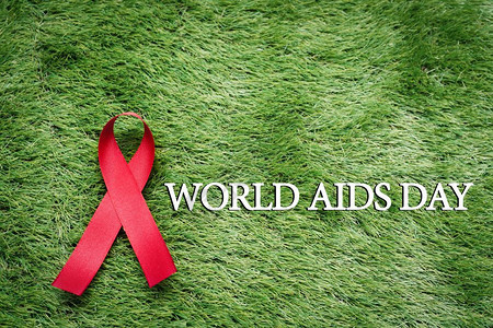 团结一致交往疾病抗艾滋在绿草上的标志AIDS意识信号红丝带图片