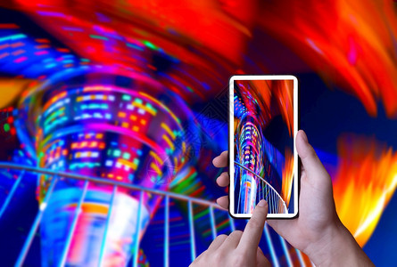 屏幕玩男人使用智能手机拍摄或录影的抽象运动片段在夜间游乐园里旋转着木马的模糊照明灯光校对Portnoy图片