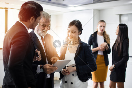 人们专业的在会议室使用讨论工作构想平板的商业人民集团在会议室中使用平板合作图片