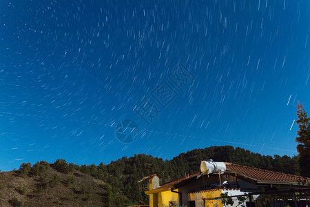 在Troodos山上一座房屋的星际轨迹飞机横越塞浦路斯Kakopetria村的天空一种黑色的景观图片