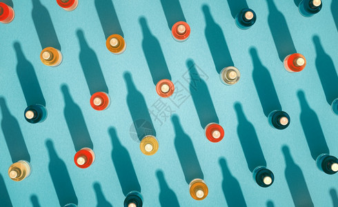 包装有金属盖的多瓶苏打玻璃的最顶部景象这些瓶子站在绿蓝底上啤酒瓶各种颜色有长阴影回声饮料瓶概念起泡苏打水图片