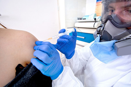 身穿防护服制和面罩的医生给女病人接种疫苗Corona爆发Covid19概念科学解毒剂眼镜图片