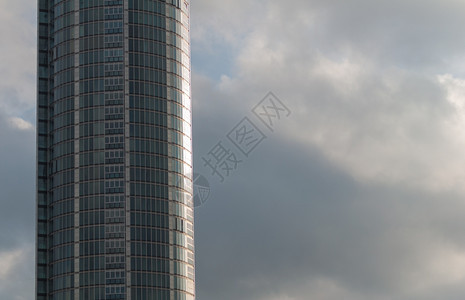 金属带有灰云的曲线玻璃办公室大楼城市商业的图片