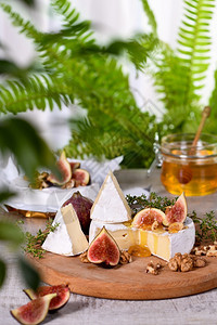 令人满意白奶酪在木板上用无花果胡桃和蜂蜜饮食调味料图片