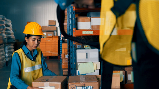 纸板盒子韩国人在仓库工作的女人物流供应链和仓库业务概念在仓库工作的女人图片
