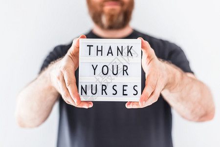 关心新冠英雄男人手拿着灯箱谢护士感在科罗纳COVID19流行期间在医院工作的生护士和疗人员谢护士们感在科罗纳COVID19中工作图片