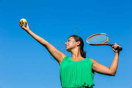 运动的抓住带网球拍和对着蓝天的年轻荷兰女青舍内维尔图片