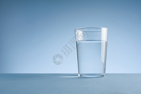 饮食凉爽的新鲜蓝色背景上一杯干净饮用水的极简主义照片带有复制空间蓝色背景上一杯干净饮用水的极简主义照片图片