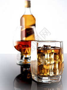 反射深色背景中加冰的威士忌在背景中一杯威士忌和整瓶深色背景中加冰的威士忌玻璃在背景中一杯加威士忌和瓶精神科涅克白兰地图片