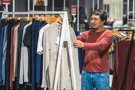 不同之处消费者在购物中心服装店挑衣寻找多彩的T恤衫时装和消费主义概念FormakinandConcentismNationali图片