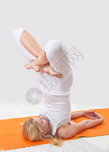 自由松弛白色的年轻漂亮女孩在专业上从事瑜伽工作图片