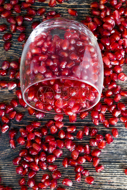 水果仍然活着的玻璃杯和红石榴颗粒分散在桌子周围健康的果实红石榴生活大约图片