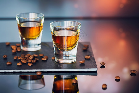 玻璃桌上的威士忌酒和咖啡豆图片