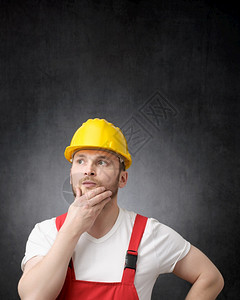 红色的一位深思熟虑建筑工人肖像和一位深思熟虑的建筑工人画像男帽子图片