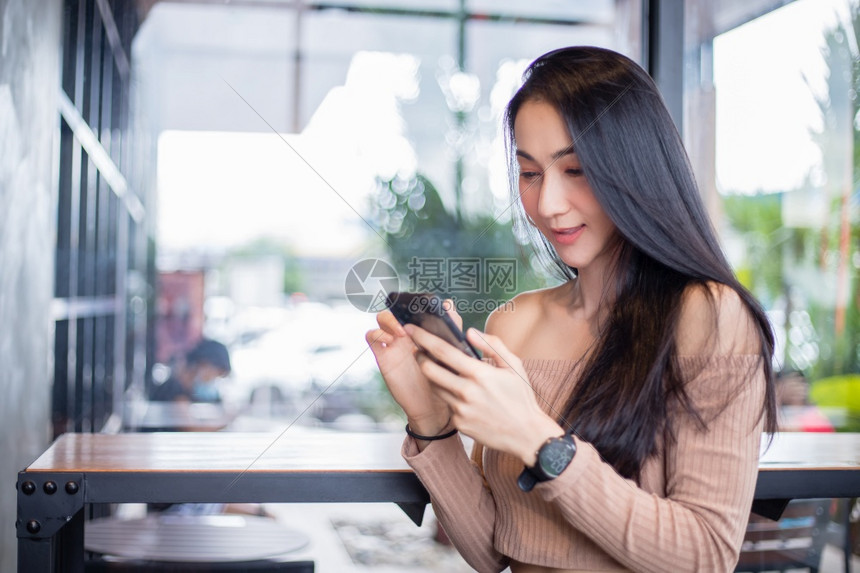 网络女微笑和快乐的亚洲商业妇女正在使用移动和触摸智能电话进行通信和搜索息技术通生活方式的概念b利用移动和触摸智能电话来寻找信息通图片