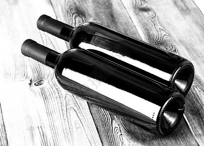 黑色的红酒杯霞多丽木制桌上的玻璃瓶酒图片