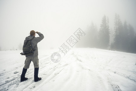 自由旅行和选择方式的概念在冬季山里背着包的人同龄进入迷雾的河边在冬天山里带背包的人同龄进入迷雾的河边距离搜索方法图片