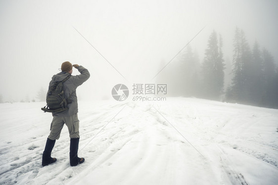 自由旅行和选择方式的概念在冬季山里背着包的人同龄进入迷雾的河边在冬天山里带背包的人同龄进入迷雾的河边距离搜索方法图片