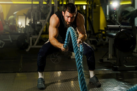 使用绳索锻炼健身的成年男子图片