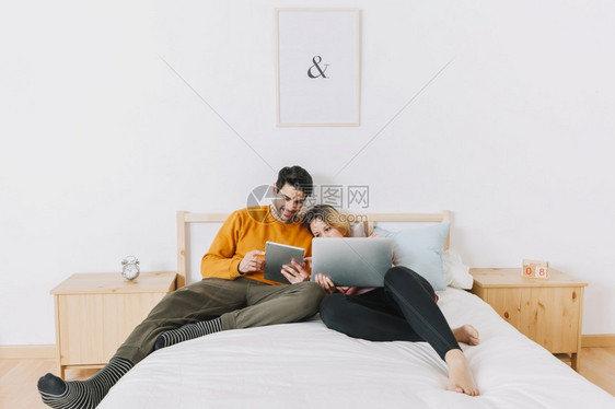 男公寓人使用技术的夫妇床图片